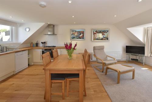 a kitchen and dining room with a wooden table and chairs at Penthouse on the Harbour - Pittenweem in Pittenweem