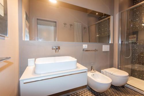 ein Bad mit einem Waschbecken, einem WC und einer Dusche in der Unterkunft Raffaello Apartment by Firenze Prestige in Florenz