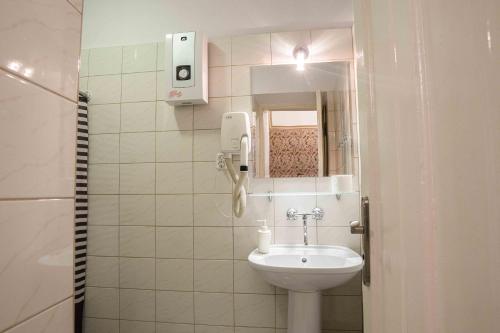 uma casa de banho com um lavatório e um telefone na parede em Florian Apartment 8 na Cracóvia