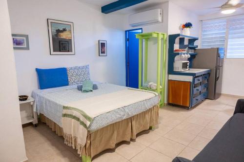 1 dormitorio con 1 cama y microondas. en Studio 3 Anacaona with Garden access, en Vieques