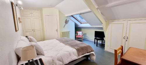 a bedroom with a bed and a desk and a chair at Résidence Ma Vallée in Us