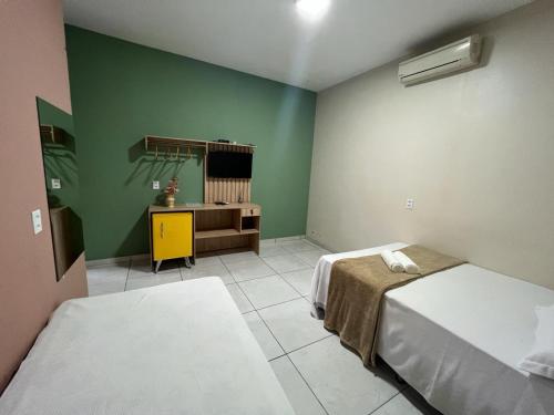 a bedroom with two beds and a dresser in it at POUSADA AMORIM in Santo Amaro
