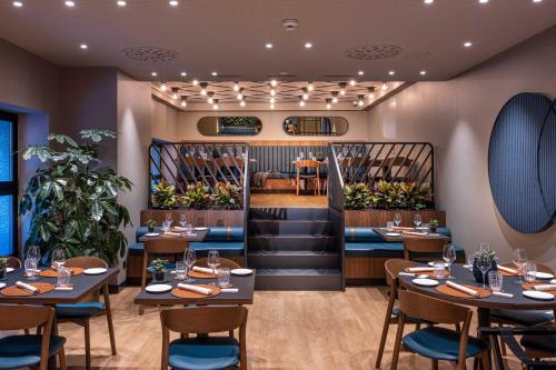 a restaurant with tables and chairs and a bar at LUGANODANTE Boutique & Lifestyle Hotel in Lugano