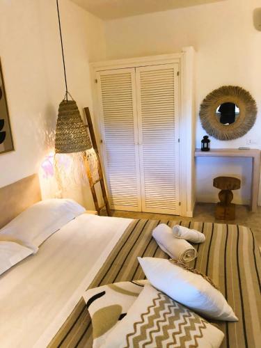 a bedroom with a bed with pillows and a mirror at Le Lanterne Resort in Pantelleria