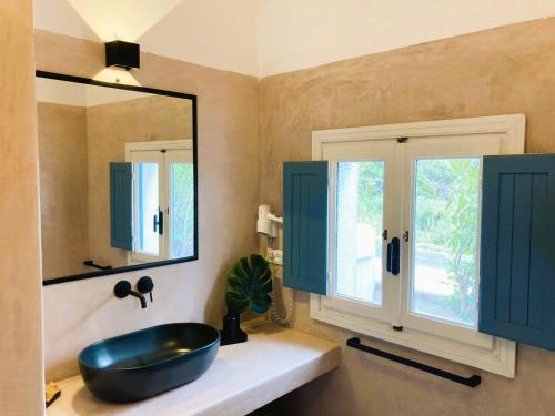 a bathroom with a black sink and a mirror at Le Lanterne Resort in Pantelleria