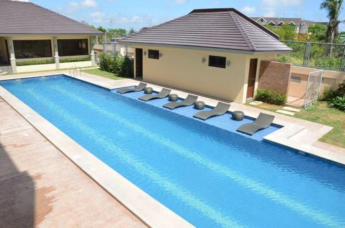 una piscina con tumbonas junto a una casa en Hotel Monticello Tagaytay, en Tagaytay