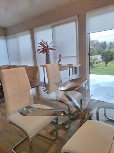 a dining room with a glass table and chairs at Garden House in São Vicente Ferreira