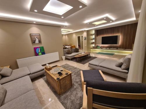 sala de estar con 2 sofás y TV en Amman's most prestigious, en Amán