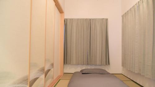 a bedroom with a bed and a window at Osaka Shinsaibashi Dotonbori Courtyard Villa in Osaka