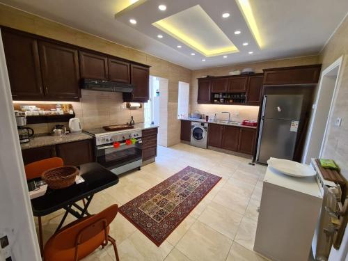 a kitchen with brown cabinets and a table and a counter at Amman's most prestigious in Amman