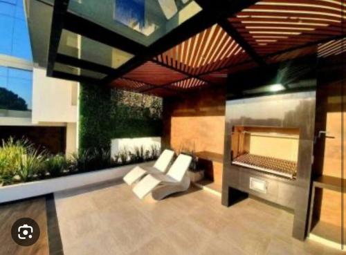sala de estar con sofá y chimenea en monoambiente completo y central, en Santa Cruz de la Sierra