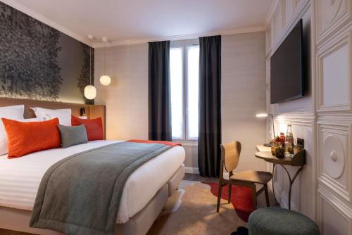 パリにあるHôtel L'Ormaie & Spaのベッドとテレビが備わるホテルルームです。
