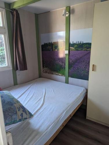 une chambre avec un lit avec un tableau sur le mur dans l'établissement Chalet climatisé en campagne avec baignade privée, à Lagnes