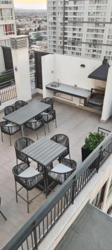 a balcony with tables and chairs on a building at Best Apartment Rental Estación Central in Santiago