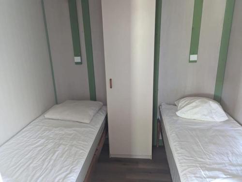 2 camas en una habitación con paredes blancas en Chalet climatisé en campagne avec baignade privée, en Lagnes