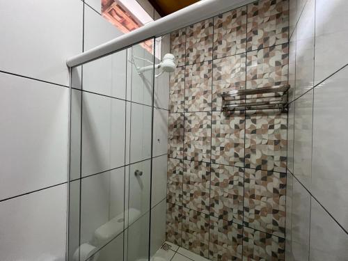 uma casa de banho com um chuveiro e uma porta de vidro em POUSADA AMORIM em Santo Amaro