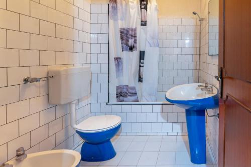 uma casa de banho com um WC azul e um lavatório. em Global Guest Sintra em Sintra