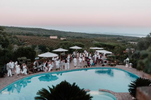 a group of people standing around a swimming pool at Villa Clodia Relais in Manziana
