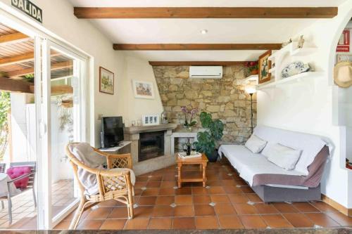ein Wohnzimmer mit einem Sofa und einem Kamin in der Unterkunft Casa Costaneira in Boiro