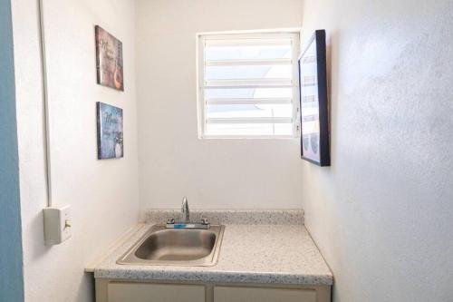 a sink in a kitchen with a window above it at Beachfront Suite 5 Cacique in Vieques