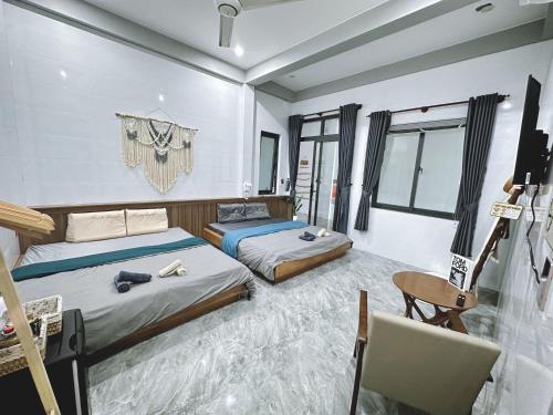 um quarto com 2 camas, uma secretária e uma cadeira em Nick’s House - Homestay Đảo Phú Quý em Cu Lao Thu