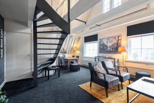 a staircase in a room with chairs and a table at Spaarne Luxury Residence Haarlem in Haarlem