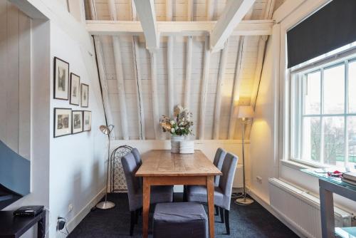 a dining room with a table and chairs and a window at Spaarne Luxury Residence Haarlem in Haarlem