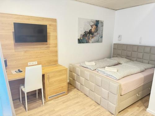 a bedroom with a bed and a desk and a television at Pension Sonnenschein in Halle an der Saale
