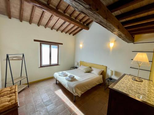 ein Schlafzimmer mit einem Bett und einem Schreibtisch. in der Unterkunft Casale dell'Assiolo Bed and Breakfast in Petrignano sul Lago