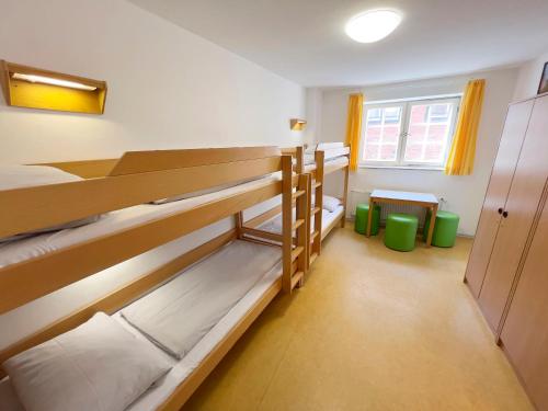 a room with two bunk beds and a window at Jugendherberge Lübeck Altstadt in Lübeck