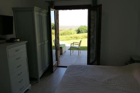 - une chambre avec un lit et une porte menant à une terrasse dans l'établissement Villa Supramonte luxury villa IUN R7796, à Marazzino