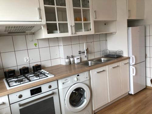 a kitchen with a washing machine and a sink at Przytulne mieszkanie w centrum. in Białystok