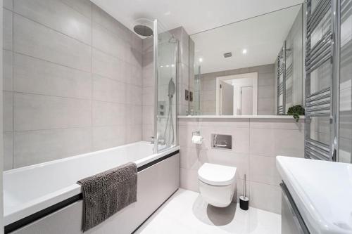 baño blanco con bañera, aseo y lavamanos en Fabulous, Modern Apartment, Solihull en Olton