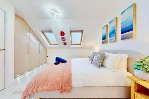 een slaapkamer met een bed en een aantal schilderijen aan de muur bij Dale House, Spacious Home in Central Dartford with Parking in Kent