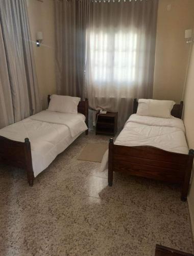 - 2 lits installés l'un à côté de l'autre dans une chambre dans l'établissement Hotel les Remparts, à Sicca Veneria