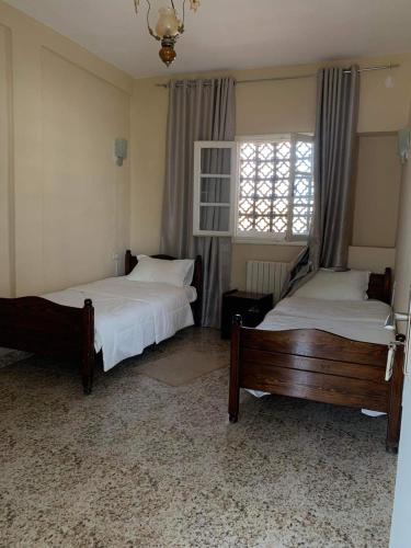 a bedroom with two beds and a window at Hotel les Remparts in Sicca Veneria