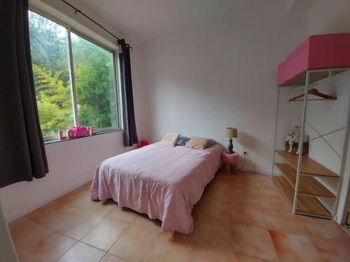 une chambre avec un lit et une grande fenêtre dans l'établissement Appartement T3 près de la mer, à La Seyne-sur-Mer