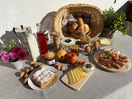 un tavolo con cibo e pane e un cesto di cibo di Rasiglerhof a Villandro
