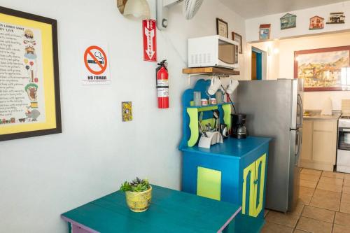 cocina con mesa azul y nevera en Beachfront Suite 6 Karaya, en Vieques