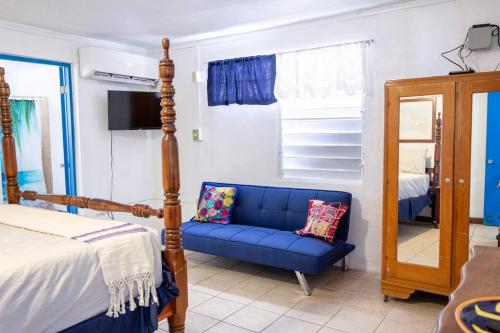 a bedroom with a blue couch and a mirror at Beachfront Suite 6 Karaya in Vieques