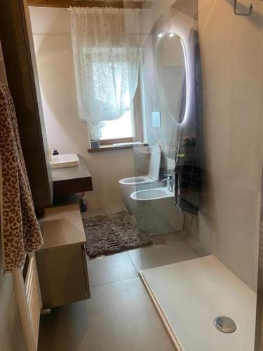a bathroom with a toilet and a sink and a window at Grazioso appartamento in Pieve Santo Stefano