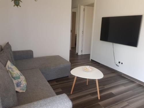 un soggiorno con divano e tavolo di Cosy 3 bedroom apartment a Flic-en-Flac