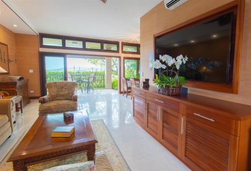 a living room with a large flat screen tv at 1412 Ridge in Kahana