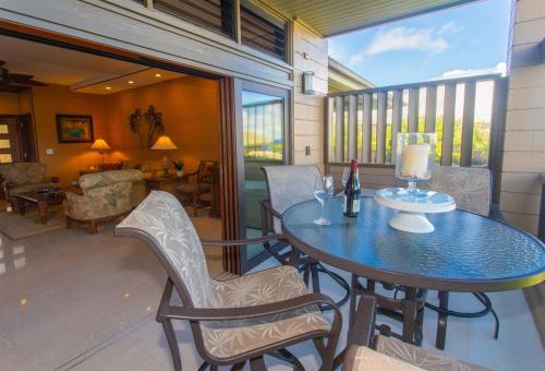 a patio with a table and chairs on a balcony at 1412 Ridge in Kahana