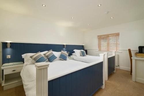 two beds in a bedroom with blue and white at The Cricket Inn in Beesands
