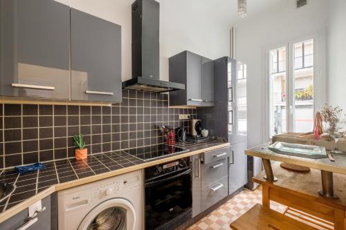 une cuisine avec une machine à laver et un lave-vaisselle dans l'établissement Palais de la paix, à Nice