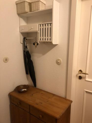 a bathroom with a wooden cabinet and an umbrella at Rosenalm App 23 in Scheidegg