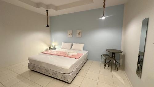 a small bedroom with a bed and a table at อิงน้ำท่าจีน (ท่าจีนรีสอร์ท) in Suphan Buri