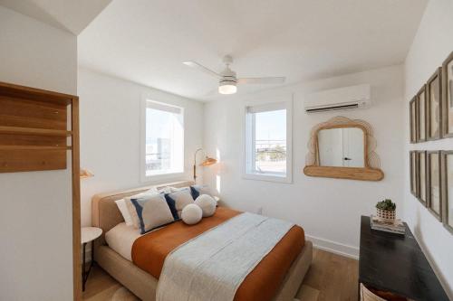 1 dormitorio con 1 cama grande y espejo en The Oceanic at The Tarrymore en Wrightsville Beach