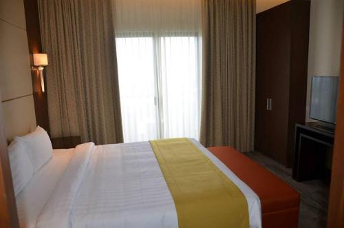 a hotel room with a bed and a television at Hotel Monticello Tagaytay in Tagaytay